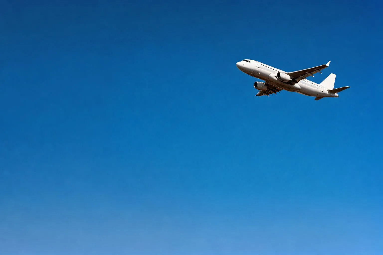 Cargo aircraft climbing into a clear sky